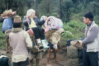 Olga in basket with sherpas helping